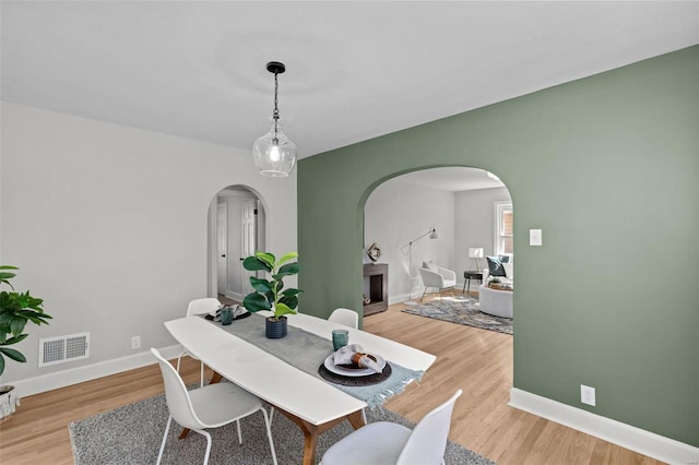 dining area with visible vents, baseboards, and light wood-style floors