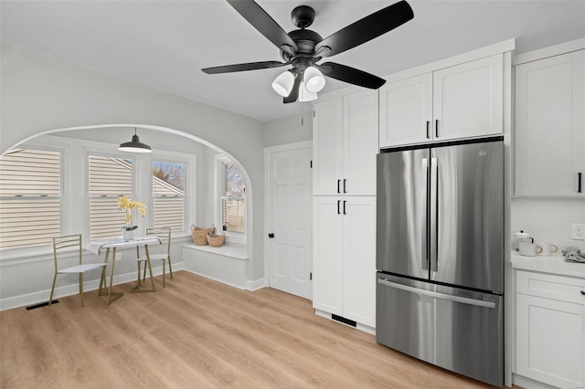 kitchen with tasteful backsplash, visible vents, freestanding refrigerator, light wood-style floors, and white cabinetry