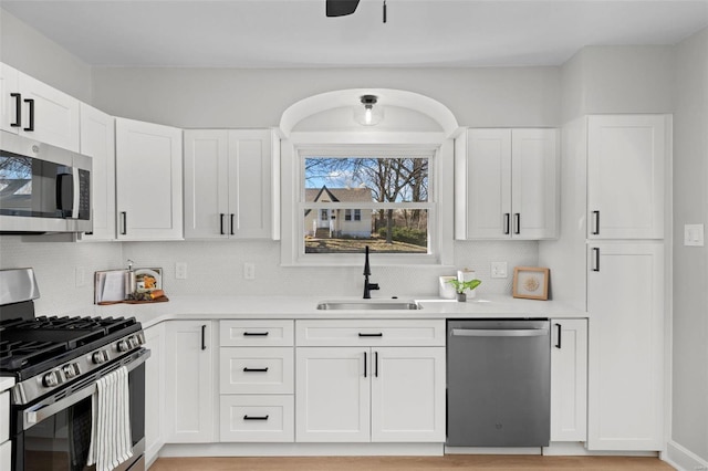 kitchen featuring a sink, white cabinetry, appliances with stainless steel finishes, and light countertops