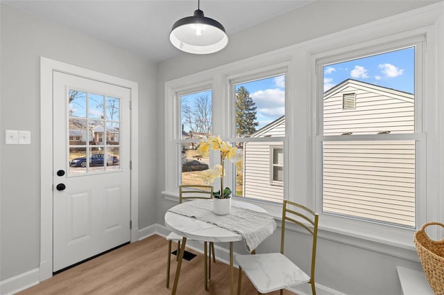 dining area featuring baseboards and light wood finished floors