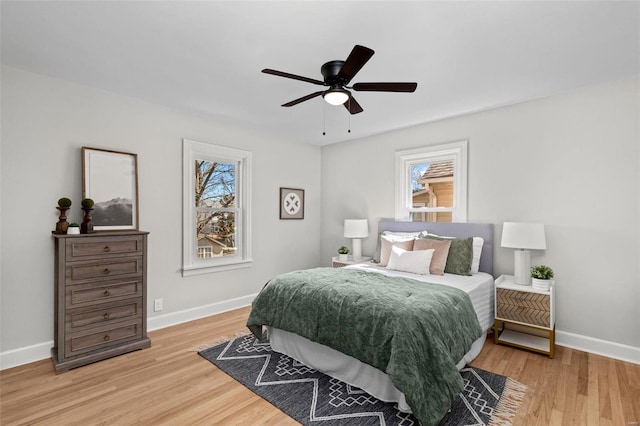 bedroom with a ceiling fan, light wood-type flooring, and baseboards