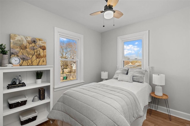 bedroom featuring ceiling fan, baseboards, and wood finished floors