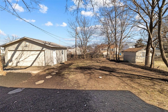 view of yard featuring an outbuilding, fence, and a garage