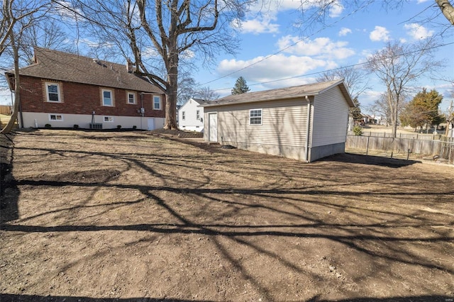 rear view of property featuring brick siding and fence