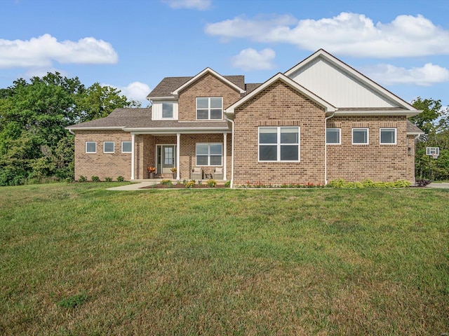 view of front of house with brick siding, a porch, and a front yard