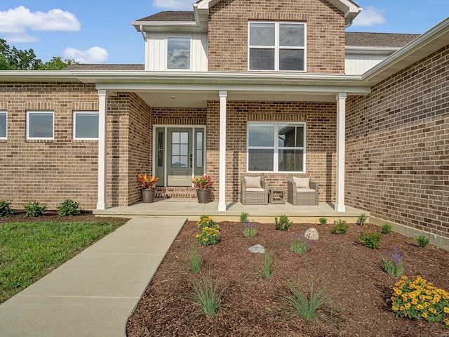 entrance to property with brick siding and a porch