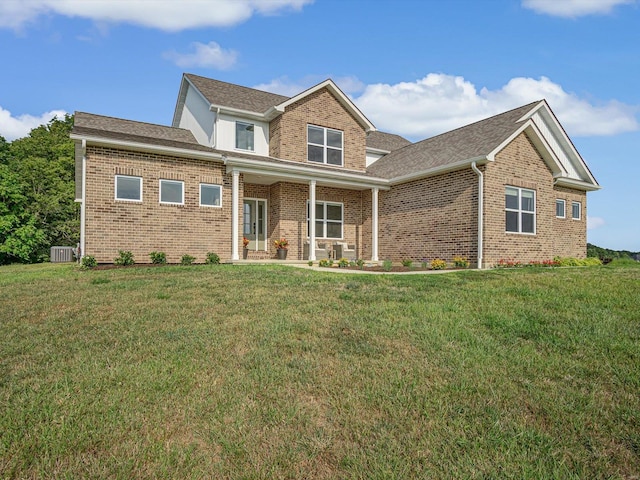 traditional home with brick siding, a porch, central AC, and a front lawn