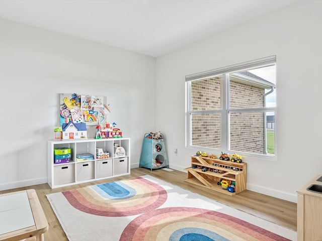 playroom with baseboards and wood finished floors