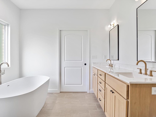 full bathroom with double vanity, a wealth of natural light, and a sink