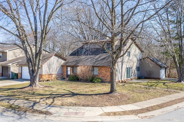 view of front of house featuring a front yard, brick siding, and driveway