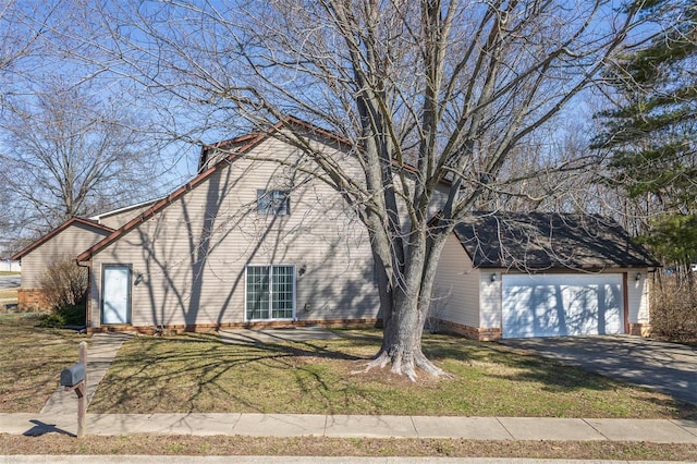 view of front of home with driveway, a front yard, and a garage