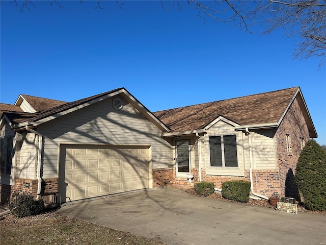 ranch-style home featuring driveway, brick siding, and an attached garage