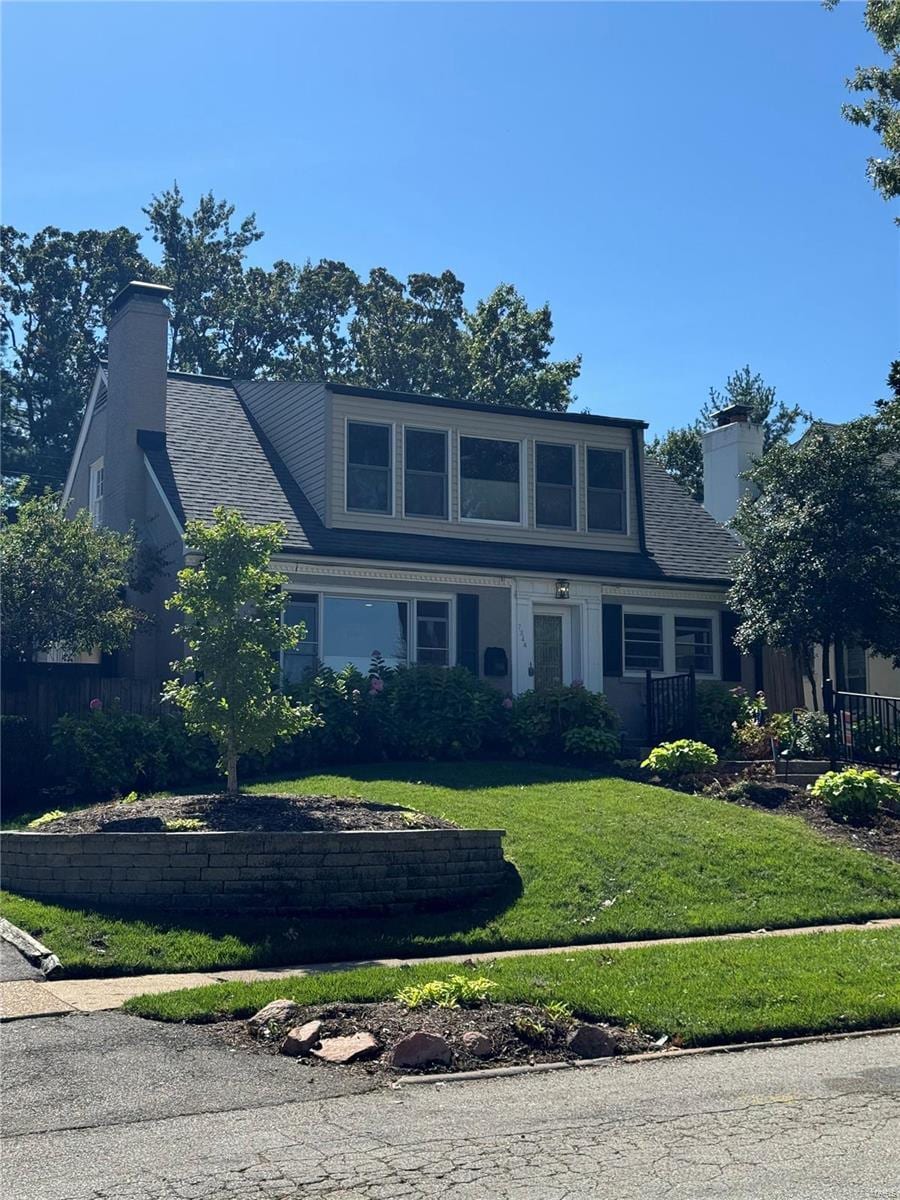 view of front of property featuring a front yard and a chimney