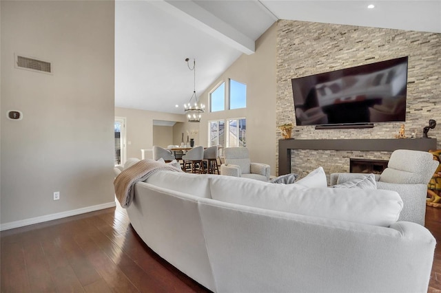 living room with visible vents, dark wood-type flooring, baseboards, beam ceiling, and a fireplace