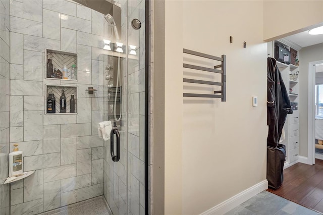 bathroom with baseboards and a shower stall