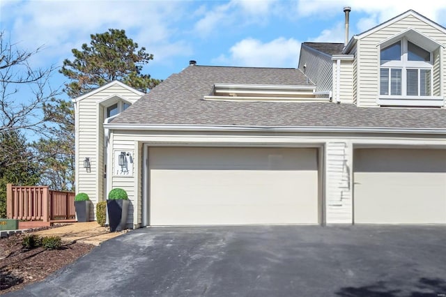 view of property exterior featuring aphalt driveway and roof with shingles