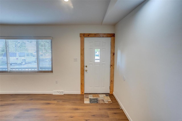 foyer entrance featuring a wealth of natural light, visible vents, baseboards, and wood finished floors