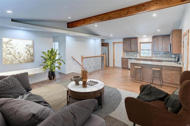 living room featuring light wood-style flooring, vaulted ceiling with beams, recessed lighting, and baseboards