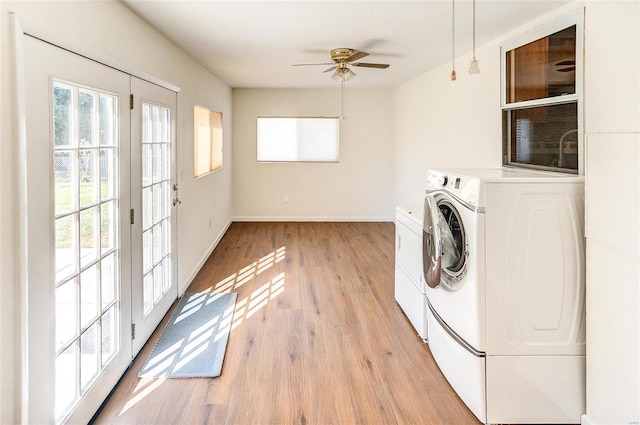 laundry room featuring light wood-style flooring, plenty of natural light, and washing machine and clothes dryer