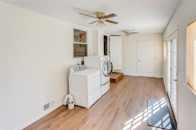 clothes washing area featuring visible vents, baseboards, light wood-style flooring, and washer and clothes dryer