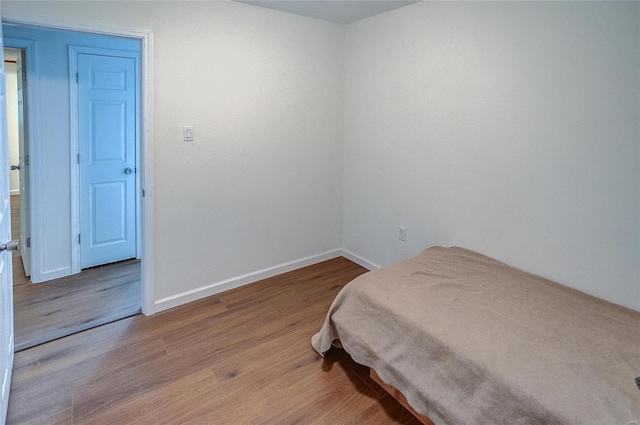 bedroom featuring wood finished floors and baseboards