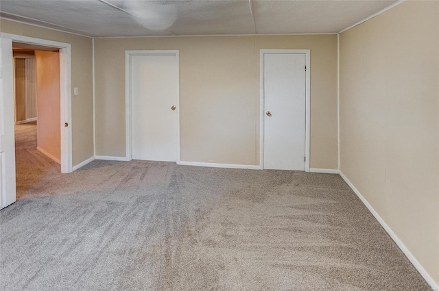 carpeted spare room featuring baseboards