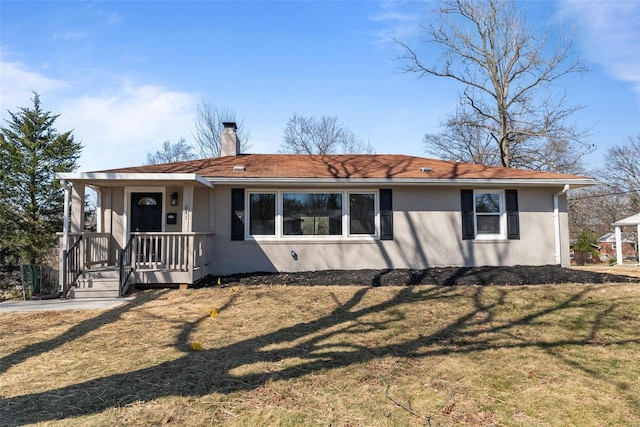 view of front of home featuring stucco siding, a front yard, and a chimney