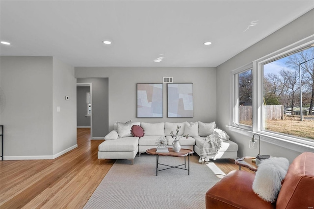 living room featuring recessed lighting, visible vents, baseboards, and light wood-style flooring