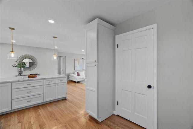 kitchen with hanging light fixtures, light wood-style flooring, recessed lighting, and white cabinets