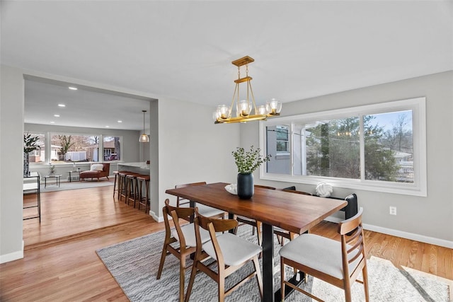 dining area featuring recessed lighting, a notable chandelier, baseboards, and light wood-style floors