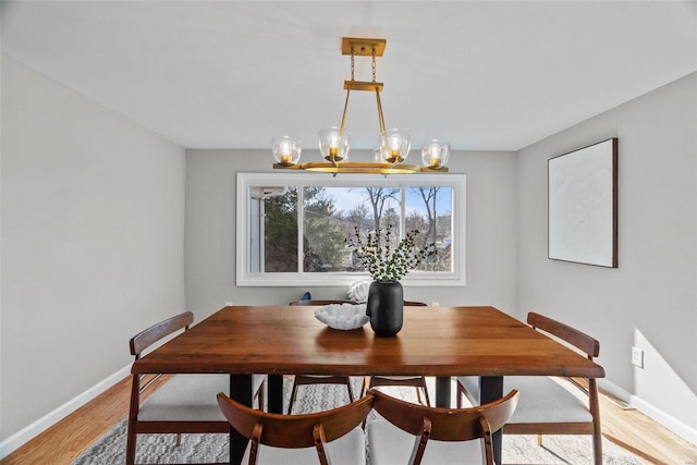 dining space with light wood-style floors and baseboards