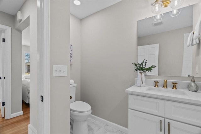 bathroom featuring vanity, baseboards, visible vents, toilet, and connected bathroom