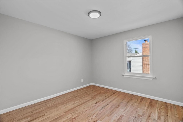 spare room featuring light wood finished floors and baseboards