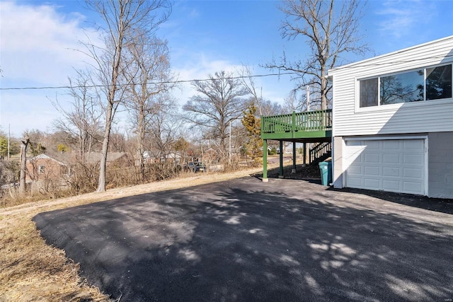 exterior space with stairway, a carport, a deck, and driveway