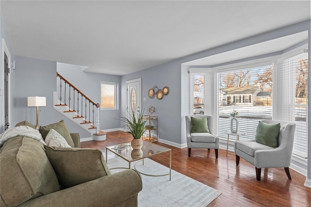 living room with stairway, baseboards, and wood finished floors