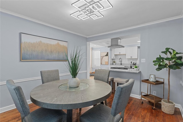 dining area with crown molding, baseboards, and wood finished floors