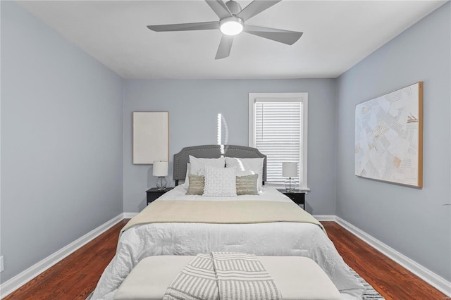 bedroom with dark wood-type flooring, a ceiling fan, and baseboards