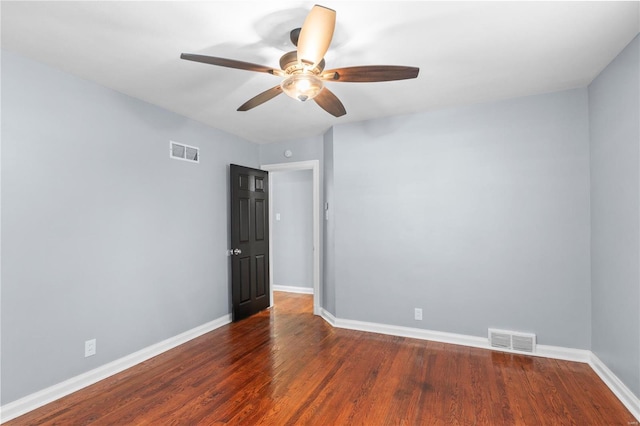spare room featuring visible vents, baseboards, and wood finished floors