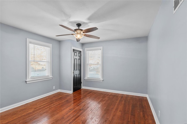 spare room with hardwood / wood-style floors, visible vents, baseboards, and ceiling fan