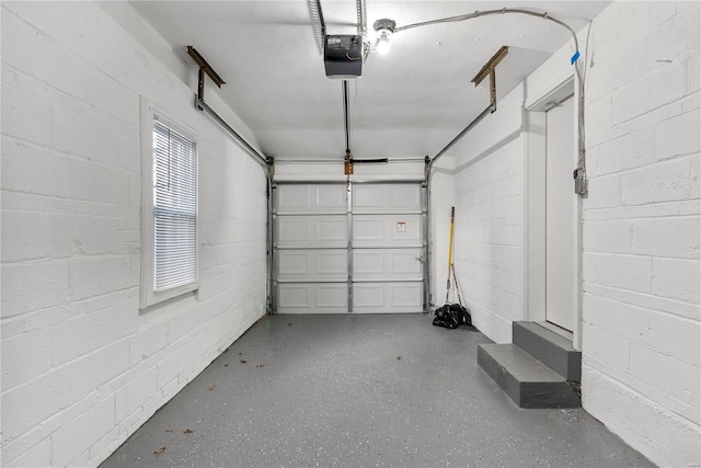 garage featuring concrete block wall and a garage door opener