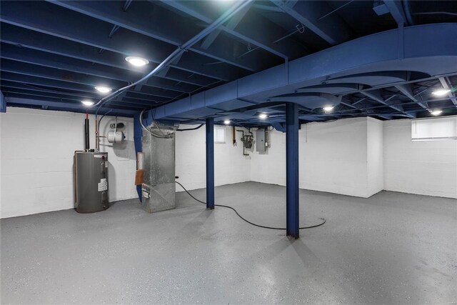 below grade area featuring electric panel, heating unit, and electric water heater