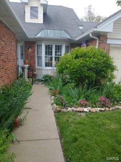 view of property exterior featuring a garage and brick siding