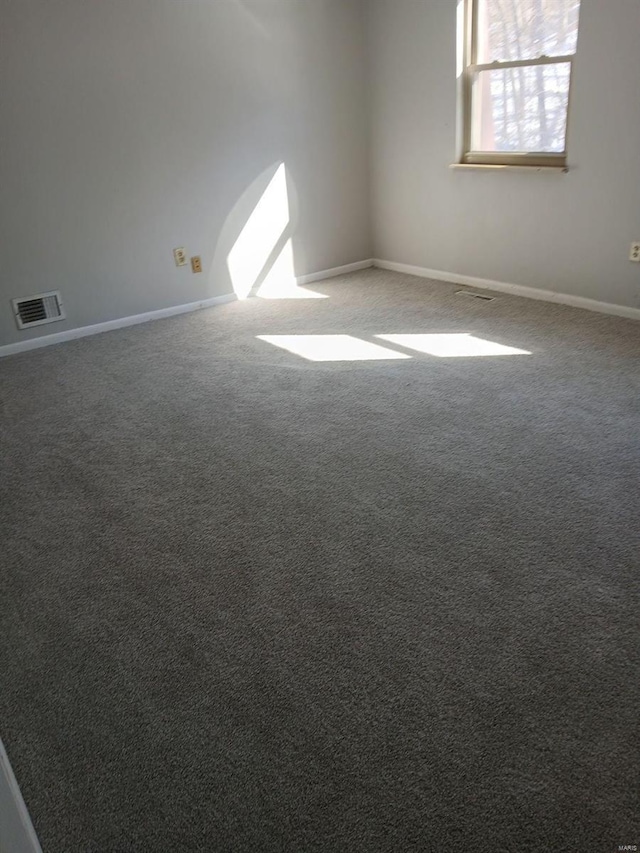 unfurnished room with visible vents, baseboards, and carpet flooring