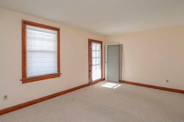 carpeted empty room with baseboards