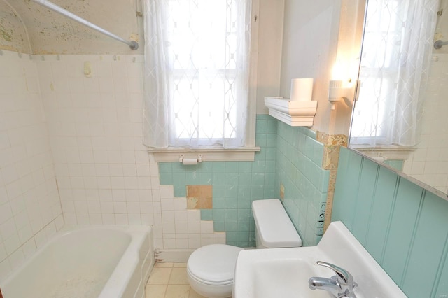 full bathroom featuring tile patterned flooring, toilet, wainscoting, tile walls, and a sink