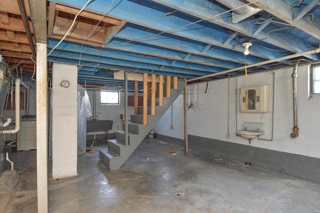 basement featuring washer / dryer, stairs, and a sink