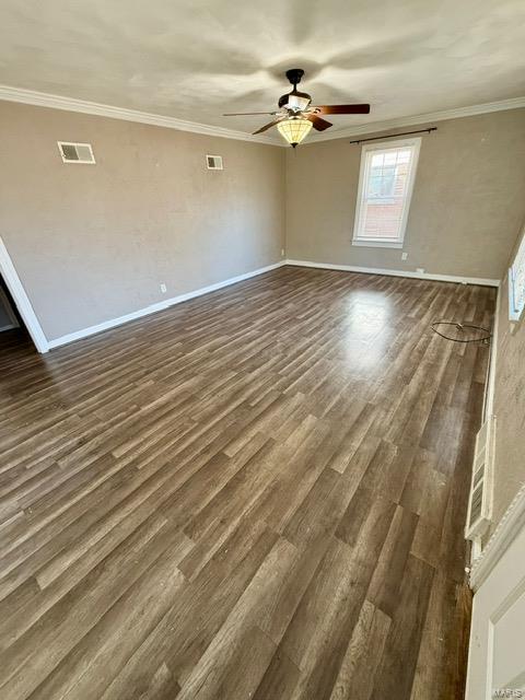 unfurnished room with crown molding, visible vents, and dark wood-style flooring