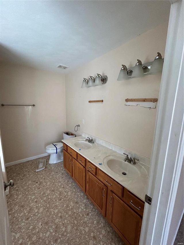 bathroom featuring double vanity, toilet, visible vents, and a sink