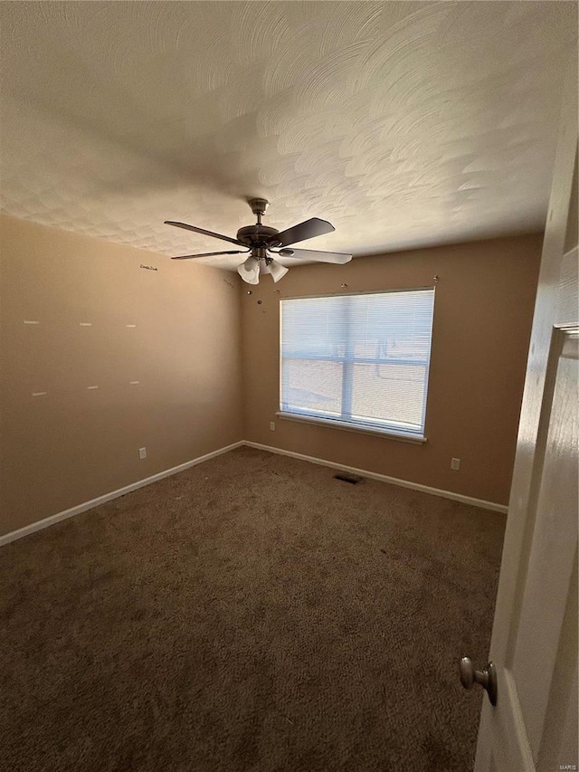 carpeted spare room featuring a ceiling fan, baseboards, visible vents, and a textured ceiling