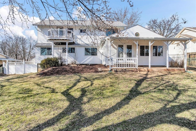 view of front of property with a front lawn, fence, covered porch, and french doors